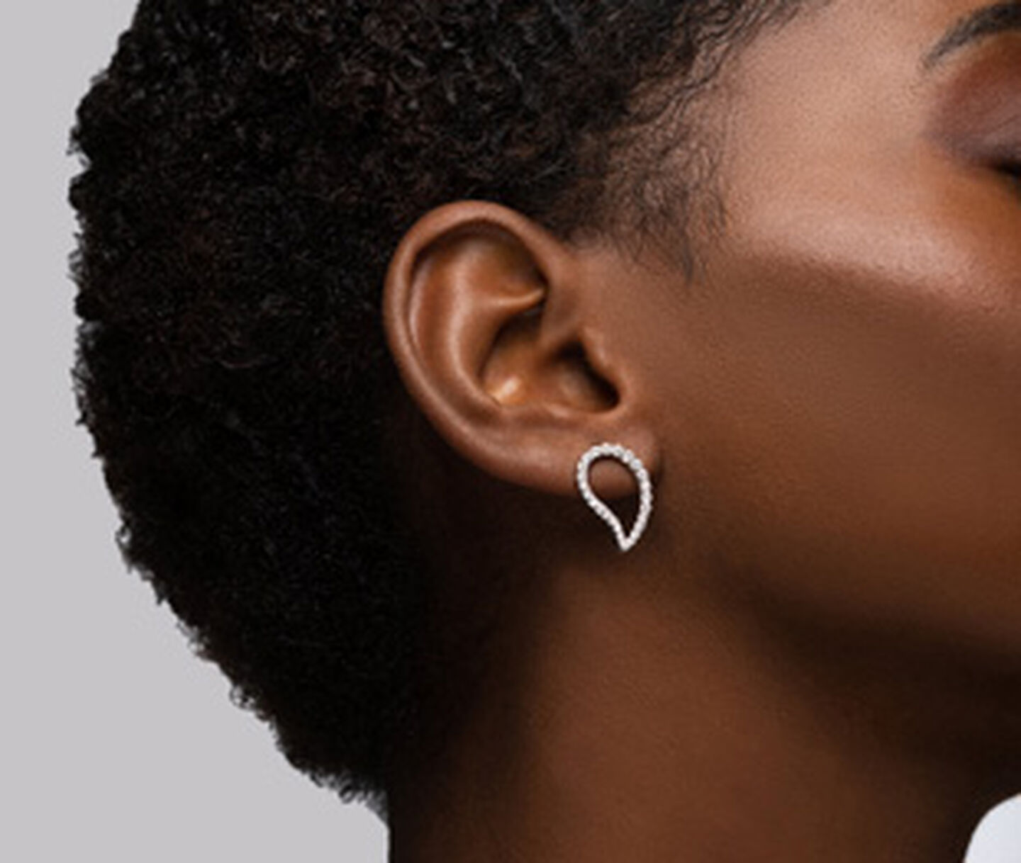A woman wearing Birks Petale diamond earrings.